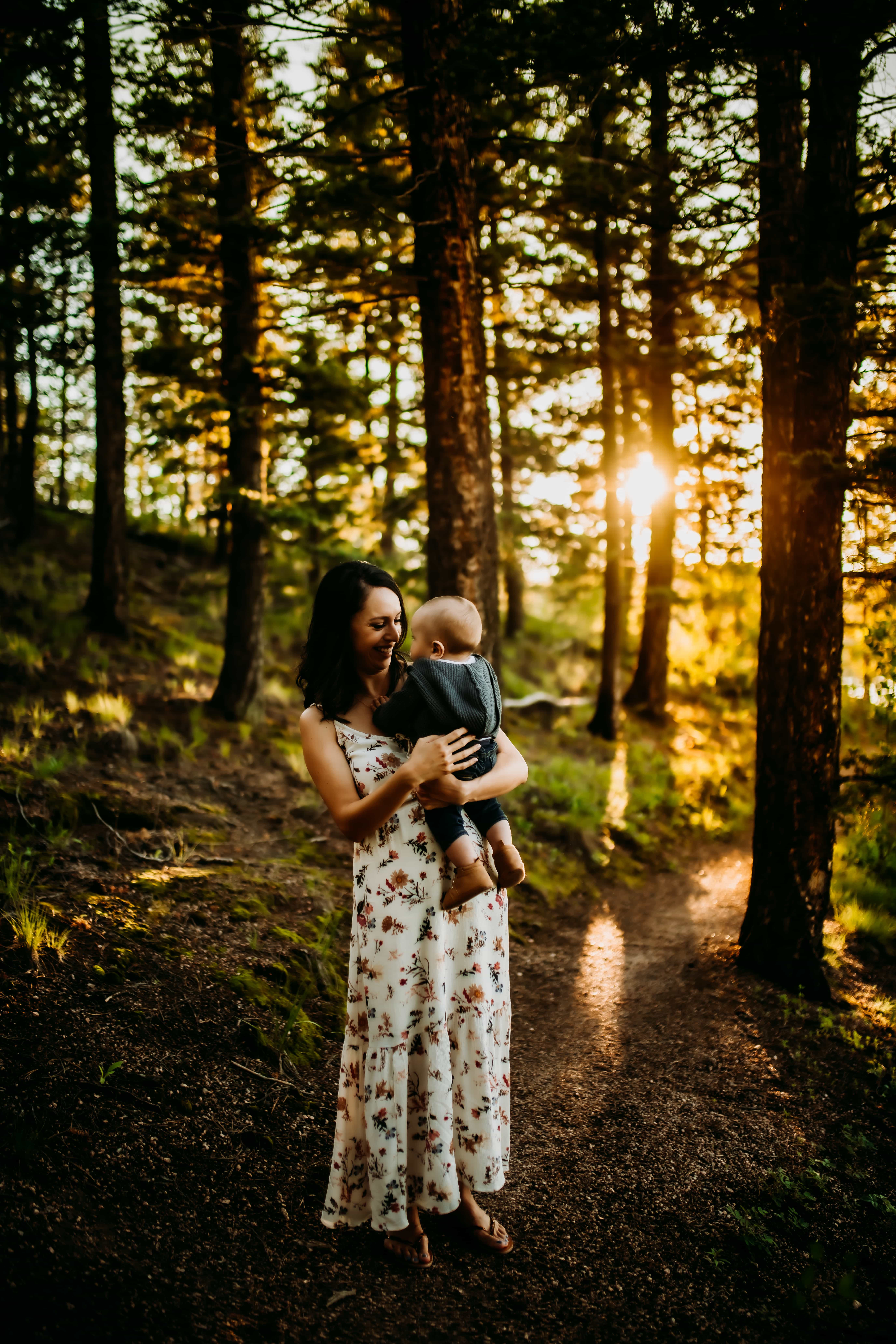 Marissa with her firstborn in a forest at golden hour